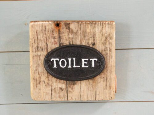 Toilet Schild auf Treibholz