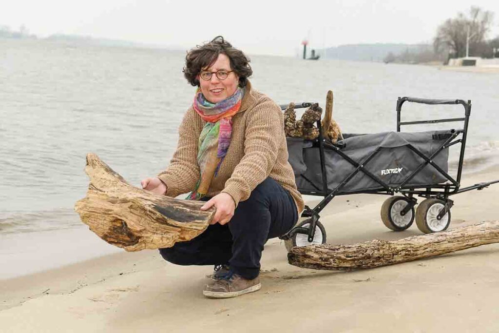 Inhaberin von Elbegut sammelt Treibholz am Strand
